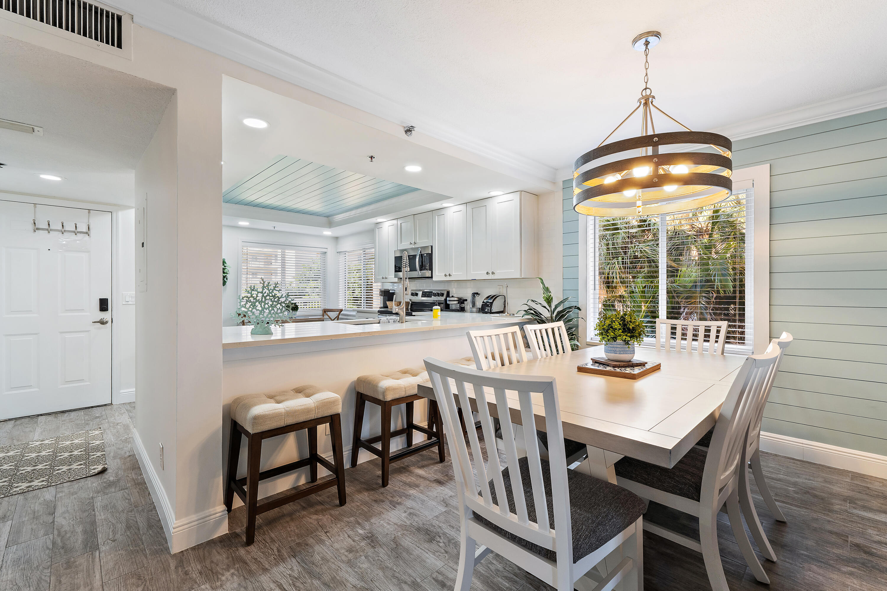 275 Palm Avenue, Unit A301 Jupiter, FL 33477 - Photo 16 of 38 a dining room with furniture a chandelier and wooden floor