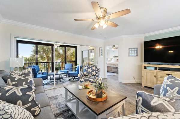 a living room with furniture kitchen view and a large window