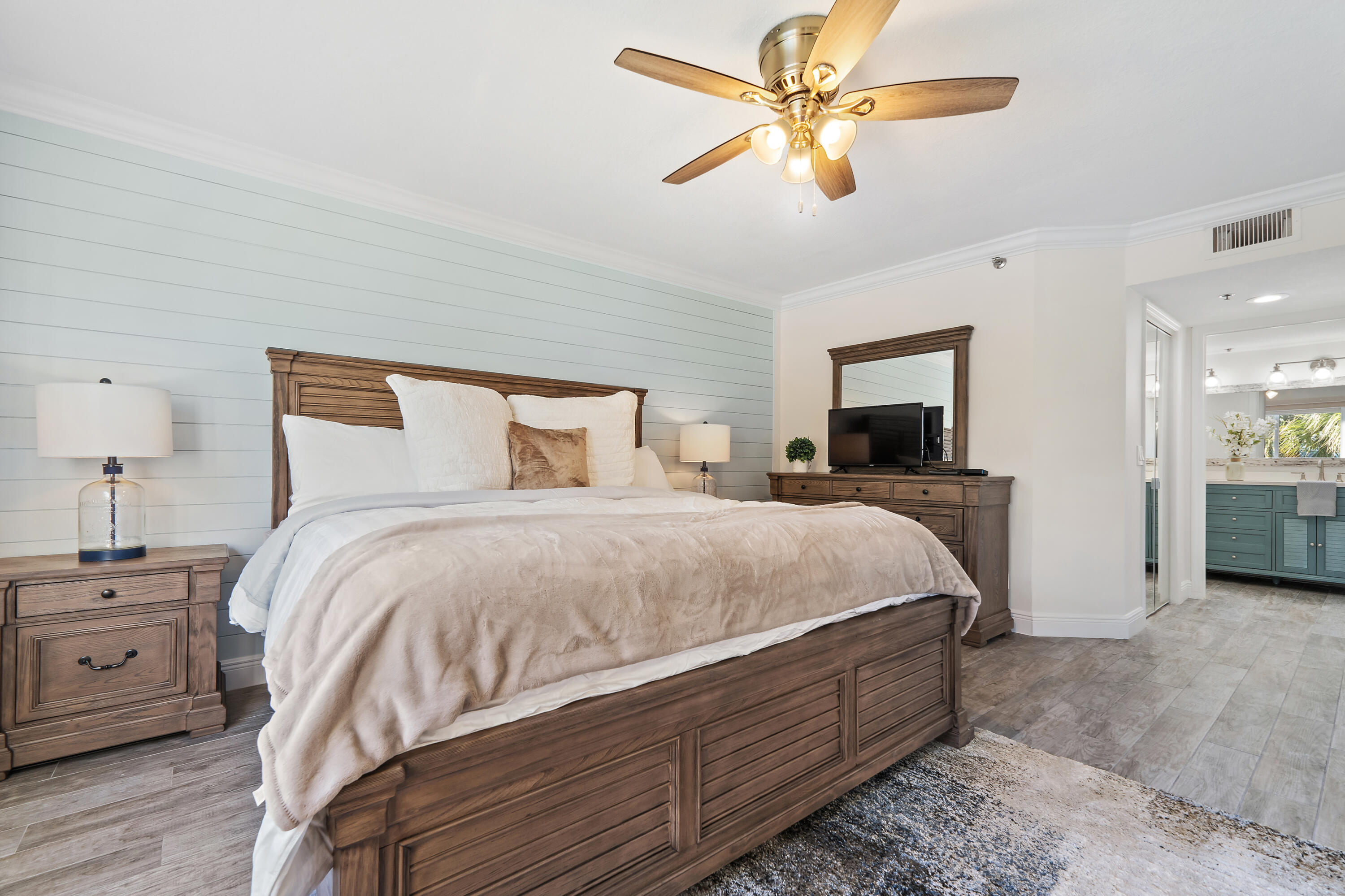 275 Palm Avenue, Unit A301 Jupiter, FL 33477 - Photo 25 of 38 a bed room with a bed a chandelier and a television