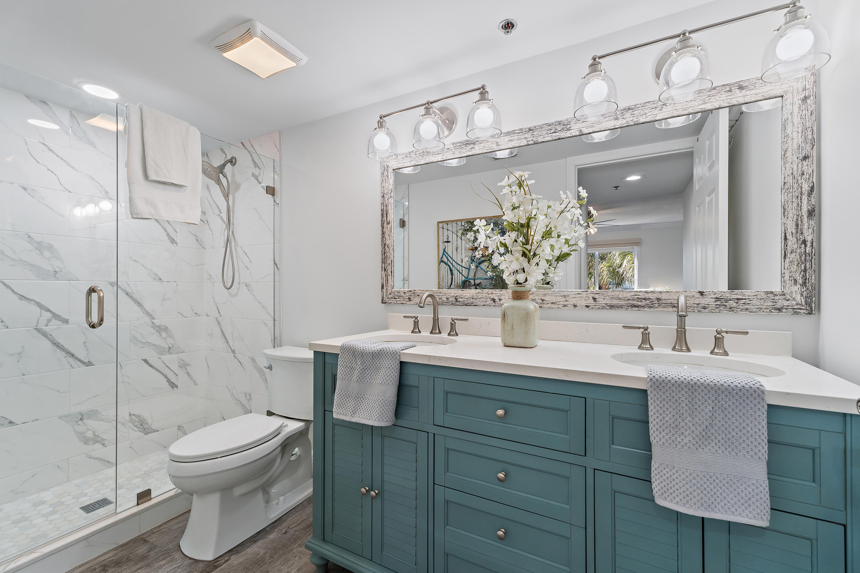 275 Palm Avenue, Unit A301 Jupiter, FL 33477 - Photo 27 of 38 a bathroom with a double vanity sink mirror and toilet