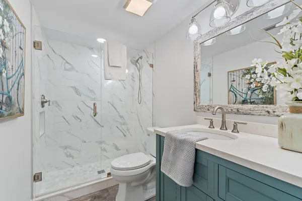 a bathroom with a sink a toilet and shower