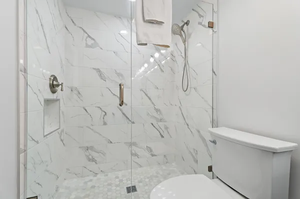 a white toilet sitting next to a shower