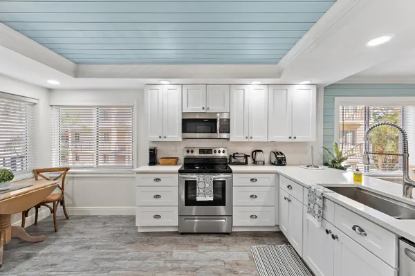 a large kitchen with stainless steel appliances granite countertop a stove and a sink