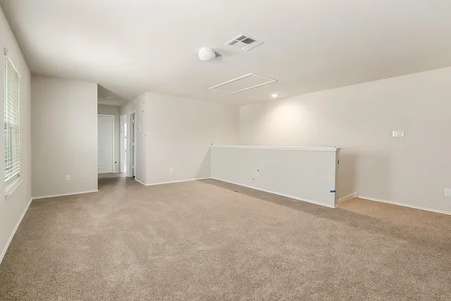 an empty room with an entryway and fan