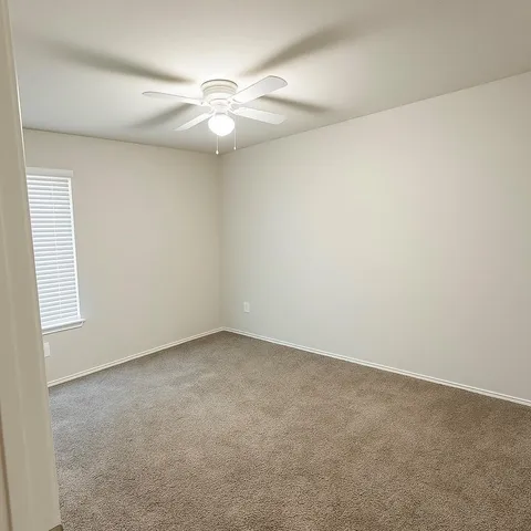 an empty room with a chandelier fan