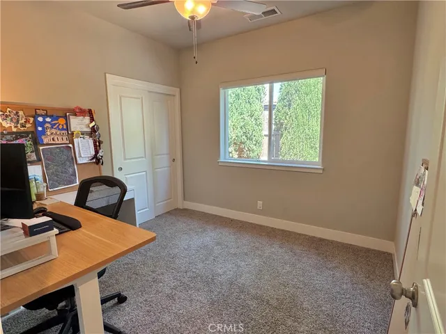 a view of a workspace with furniture and a window