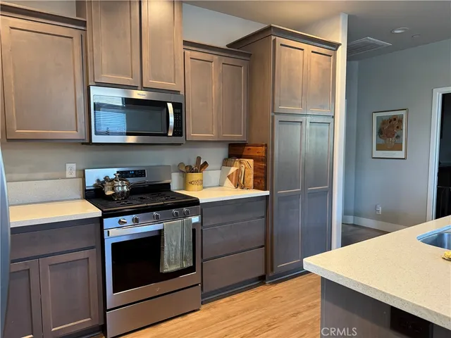 a kitchen with stainless steel appliances granite countertop a refrigerator stove and sink