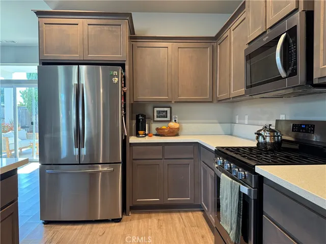 a kitchen with a refrigerator sink and cabinets