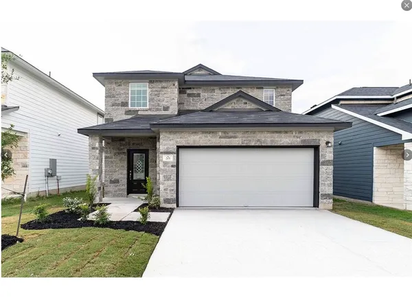 a front view of a house with a garden and yard