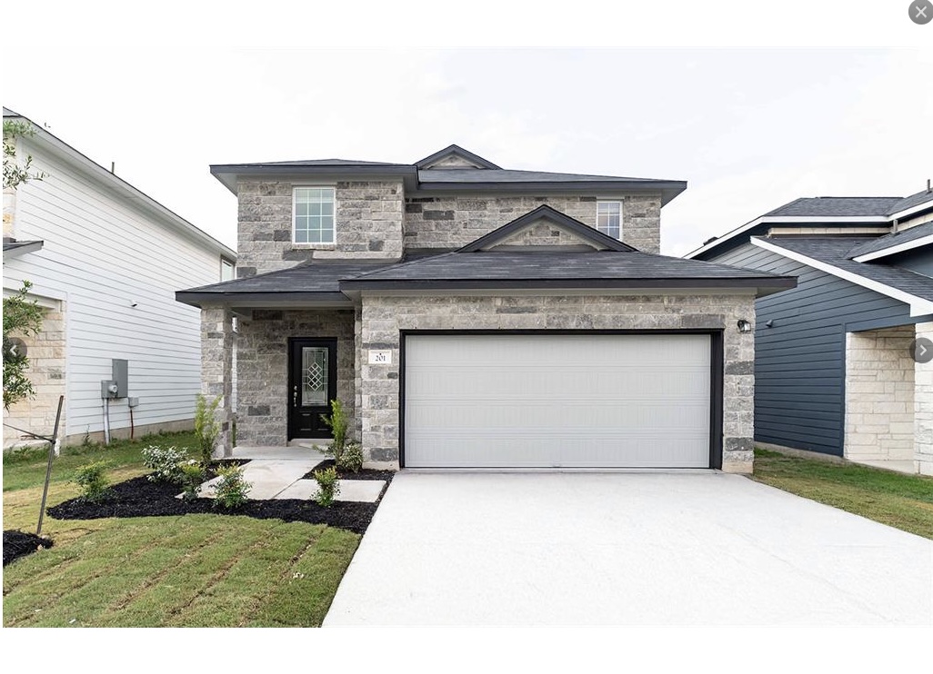 a front view of a house with a garden and yard