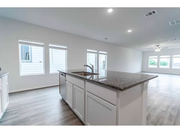a kitchen with granite countertop a sink and wooden floor