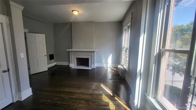 a view of a livingroom with wooden floor and a fireplace