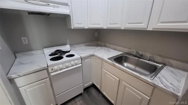 a kitchen with white cabinets and white appliances