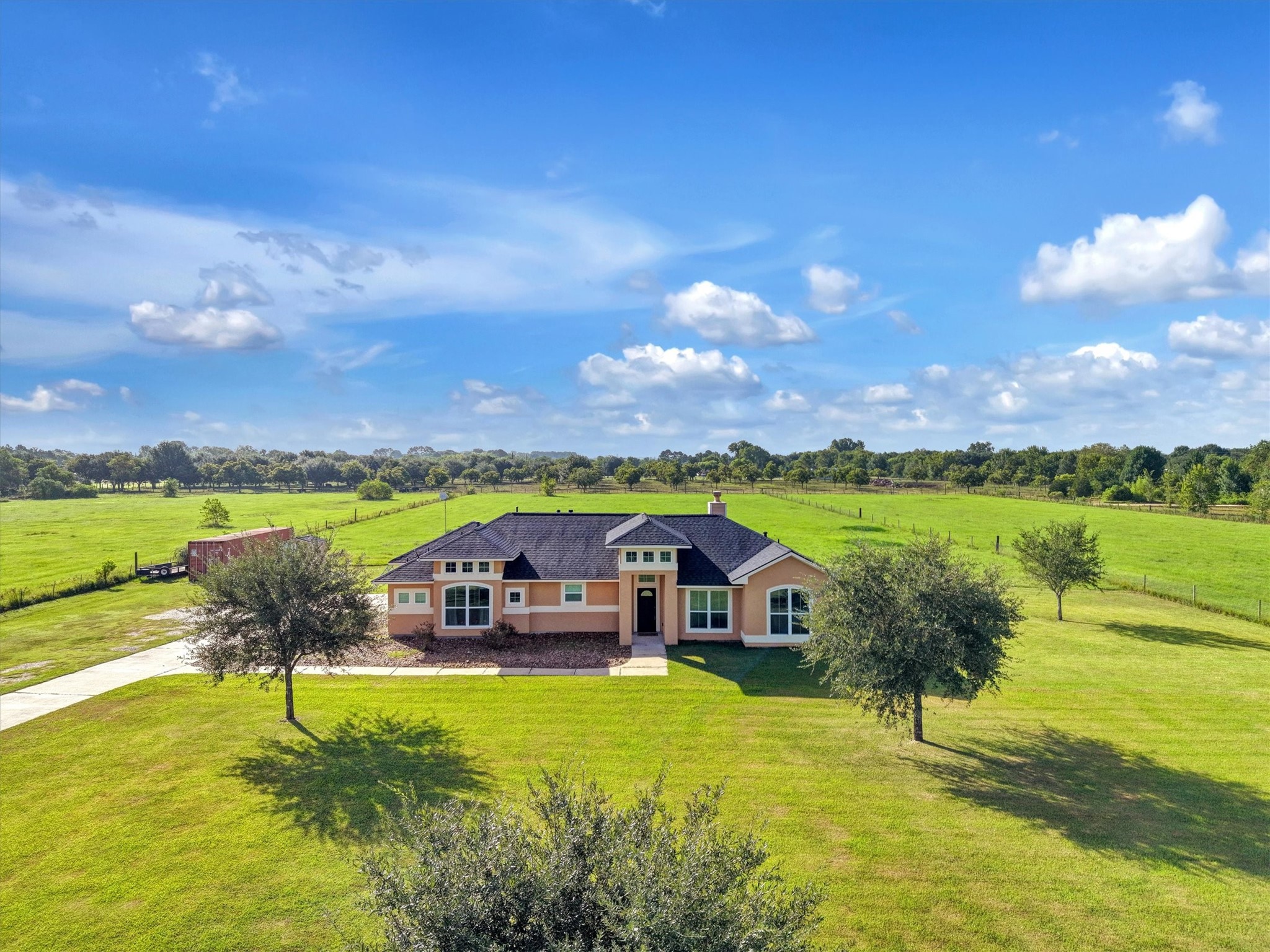 8131 Brinkmeyer Road Needville, TX 77461 - Photo 18 of 49 Spacious ranch-style home set on a vast, lush green property with open skies and serene countryside views.