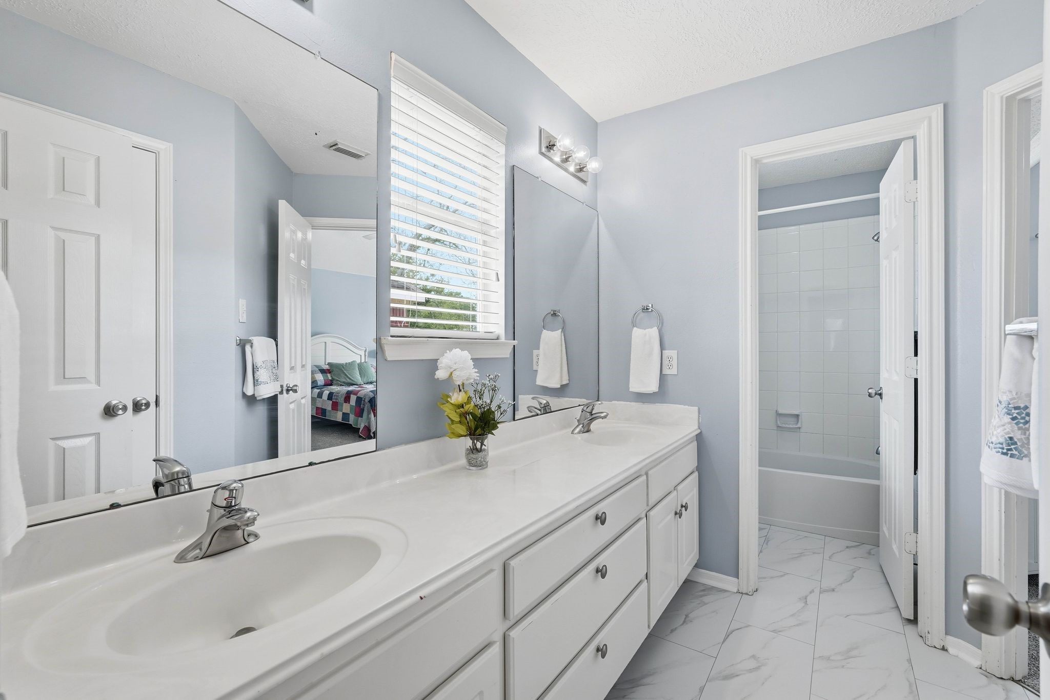 2515 Woodsboro Drive Spring, TX 77388 - Photo 33 of 44 This bathroom features a double vanity with ample storage, a large mirror, and a nuetral color scheme. It includes a tub/shower combination and modern lighting, offering a clean and inviting space.