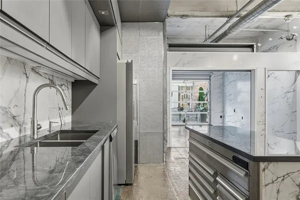 a view of a hallway with wooden floor and a kitchen