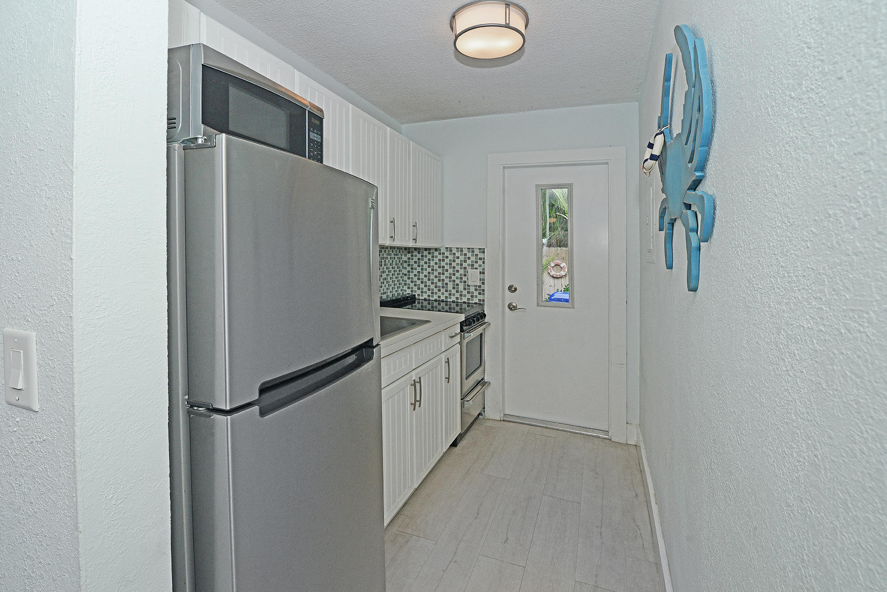 1257 Beach Road Singer Island, FL 33404 - Photo 44 of 71 a kitchen with a refrigerator and white cabinets