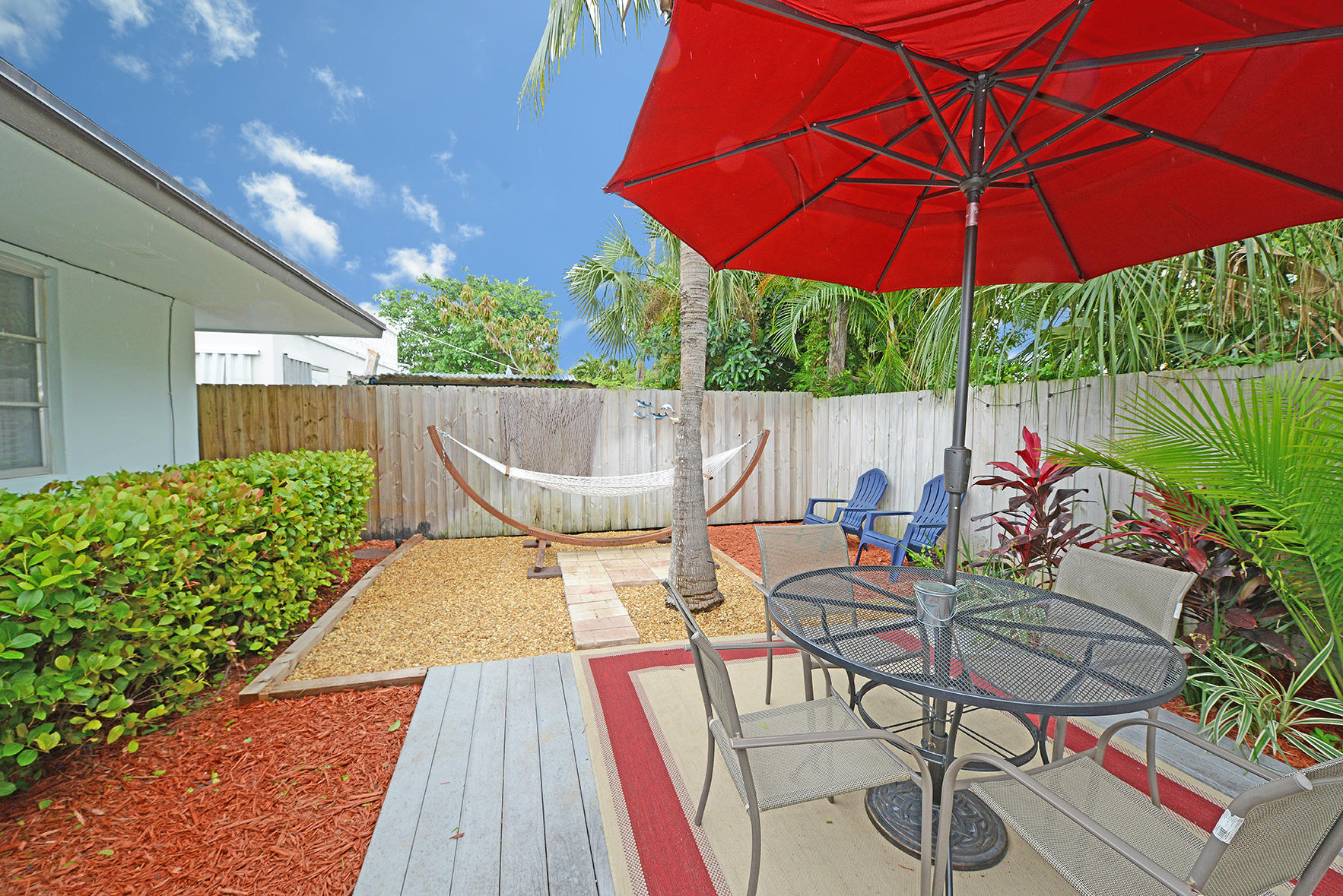 1257 Beach Road Singer Island, FL 33404 - Photo 47 of 71 a view of a patio with table and chairs under an umbrella