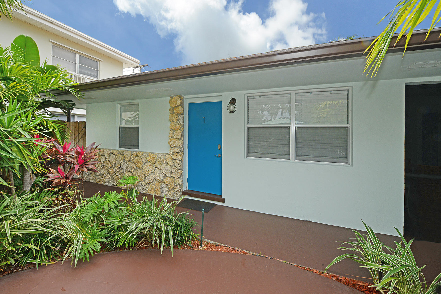 1257 Beach Road Singer Island, FL 33404 - Photo 6 of 71 a front view of a house with a yard