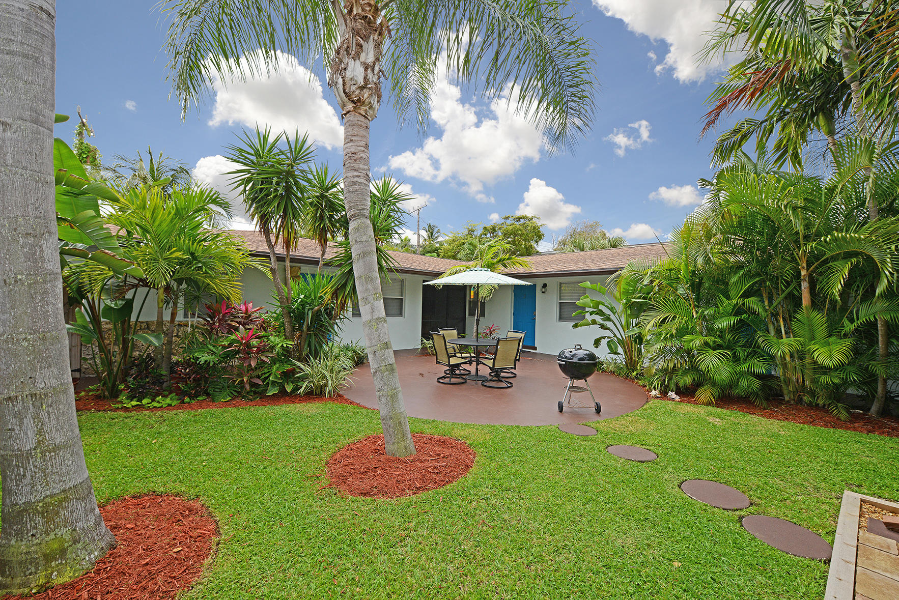 1257 Beach Road Singer Island, FL 33404 - Photo 10 of 71 a view of a backyard with table and chairs potted plants and palm tree