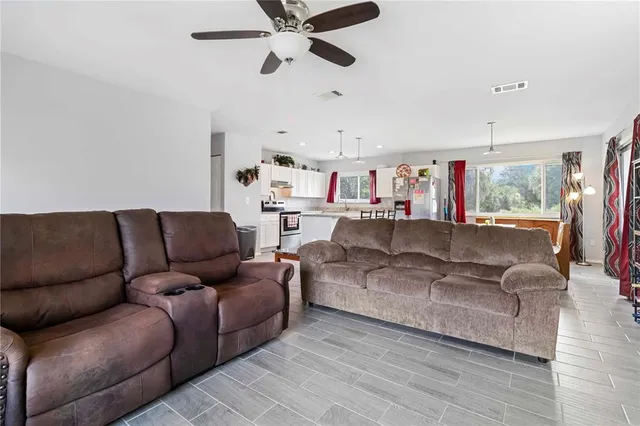 a living room with furniture and a ceiling fan