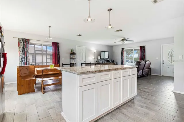 a kitchen with stainless steel appliances kitchen island granite countertop a sink and cabinets