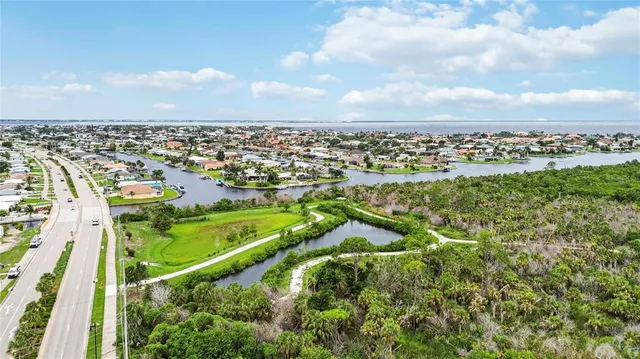 an aerial view of residential houses with outdoor space and trees
