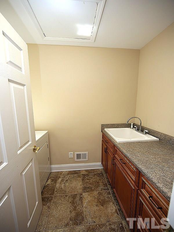 1315 Chaney Road Raleigh, NC 27606 - Photo 15 of 25 Complete with a utility sink and cabinetry for storage, this laundry room has it all.