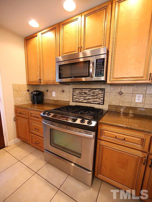 1315 Chaney Road Raleigh, NC 27606 - Photo 8 of 25 All the bells & whistles found here - soft close cabinetry, granite counter tops, stainless appliances tile backsplash, recessed can lighting.
