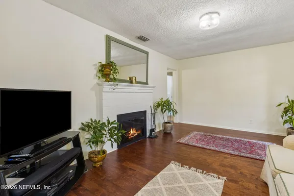 a living room with furniture a flat screen tv and a fireplace