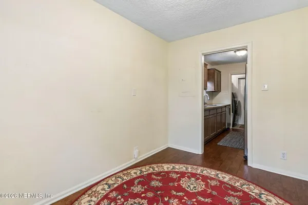 a view of hallway with a door and wooden floor