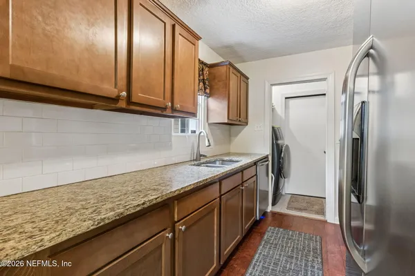 a kitchen with stainless steel appliances granite countertop a sink stove and refrigerator
