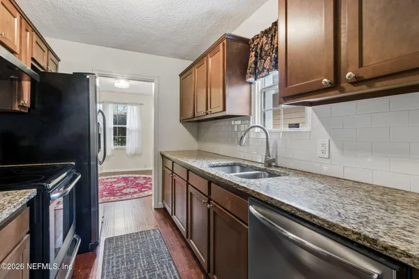 a kitchen with stainless steel appliances granite countertop a sink stove and cabinets