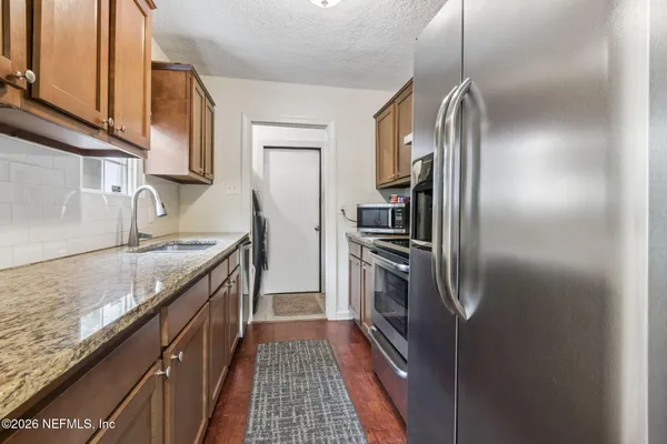a kitchen with stainless steel appliances granite countertop a refrigerator and a sink
