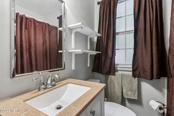 a bathroom with a sink a toilet and a mirror
