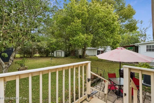 a view of a patio with table and chairs under an umbrella
