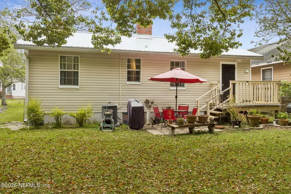 a view of a house with backyard and sitting area