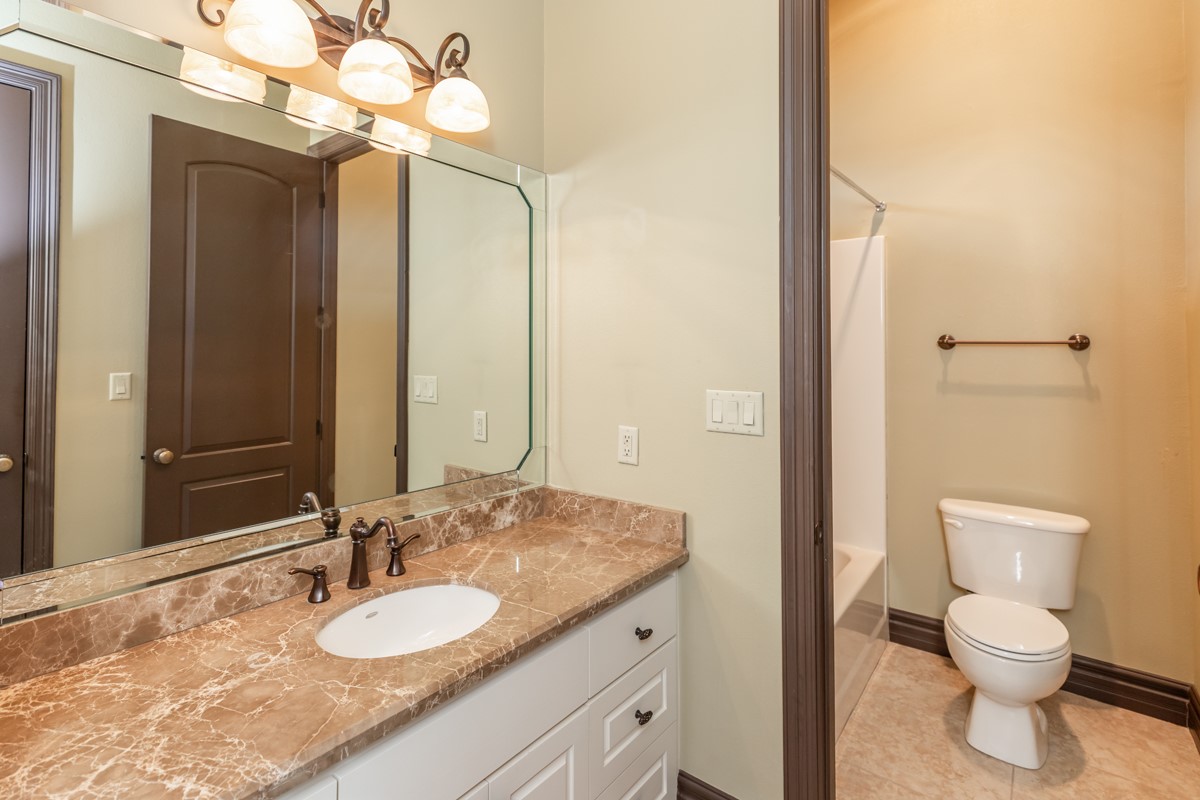 3365 Esplanade Beaumont, TX 77707 - Photo 29 of 33 a bathroom with a granite countertop sink a toilet and a mirror