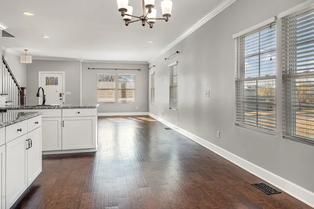 a large white kitchen with granite countertop a large window