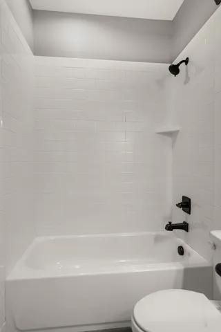 a bathroom with a toilet and a bath tub