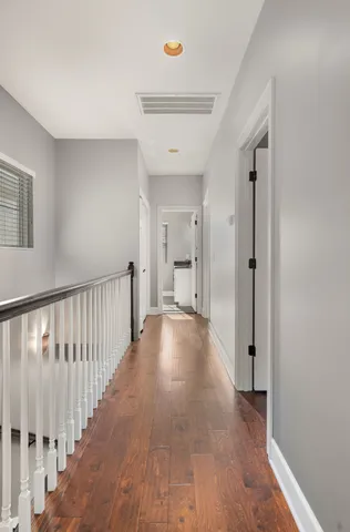 a view of a hallway with wooden floor and staircase
