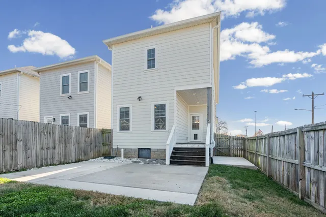 a view of a house with a yard and wooden fence