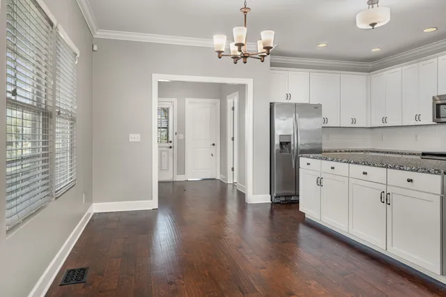a view of a kitchen with stainless steel appliances granite countertop a refrigerator and a stove top oven