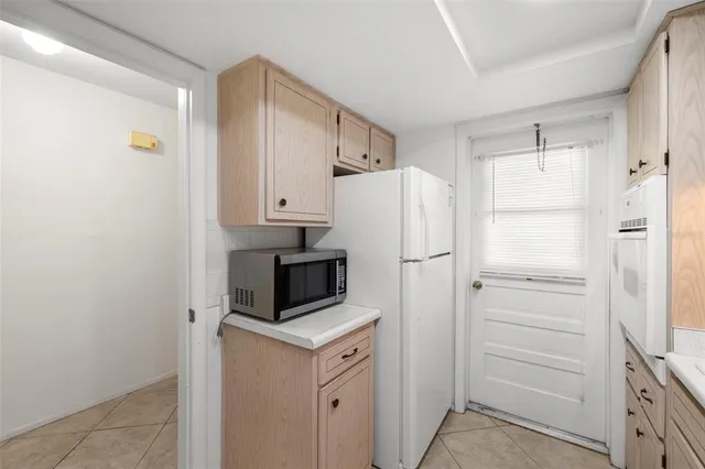 a kitchen with a refrigerator a stove and white cabinets