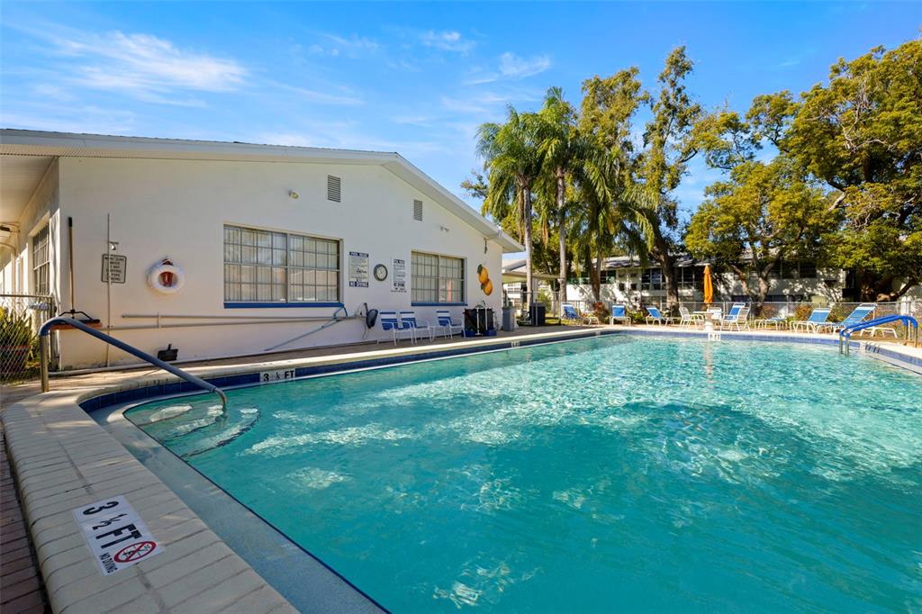 400 Glennes Lane, Unit 206 Dunedin, FL 34698 - Photo 25 of 49 a house view with swimming pool and trees in the background