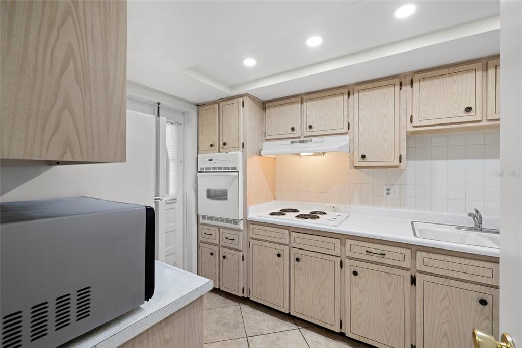400 Glennes Lane, Unit 206 Dunedin, FL 34698 - Photo 9 of 49 a kitchen with cabinets appliances and a window