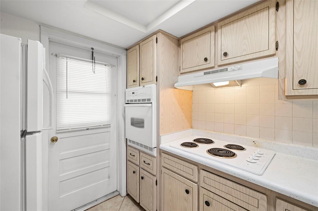 400 Glennes Lane, Unit 206 Dunedin, FL 34698 - Photo 10 of 49 a kitchen with white cabinets and white appliances