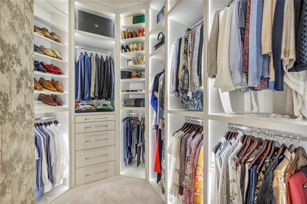 210 Lavaca Street, Unit 2706 Austin, TX 78701 - Photo 32 of 32 Custom-designed walk-in closet featuring built-in shelving, integrated lighting, multiple hanging rods, and a central dresser with five drawers