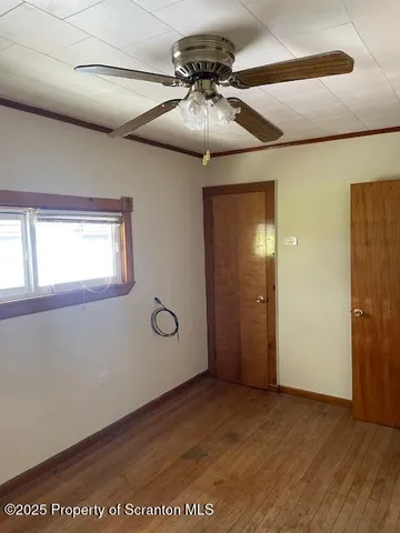 a view of a livingroom with a chandelier fan and wooden floor