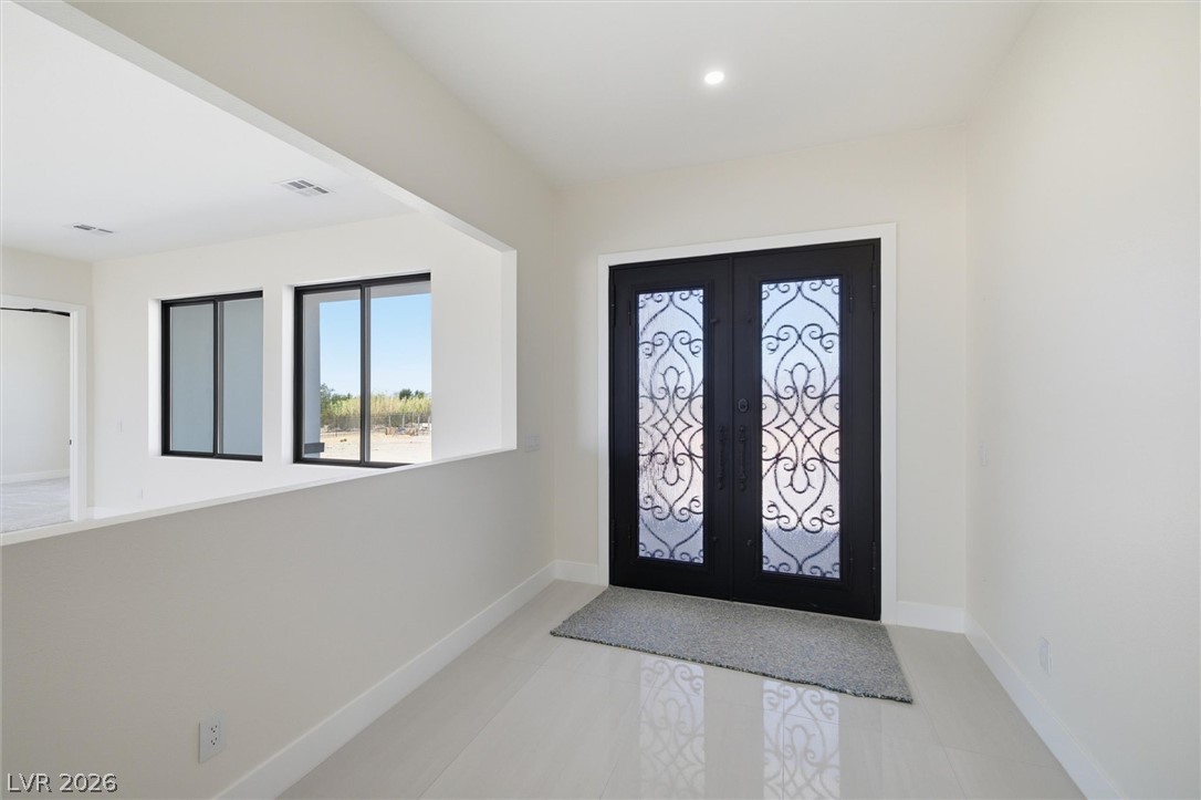 5910 East Kellogg Road Pahrump, NV 89061 - Photo 9 of 58 Ornate wrought iron doors welcome you into this light-filled entry, featuring polished tile flooring.